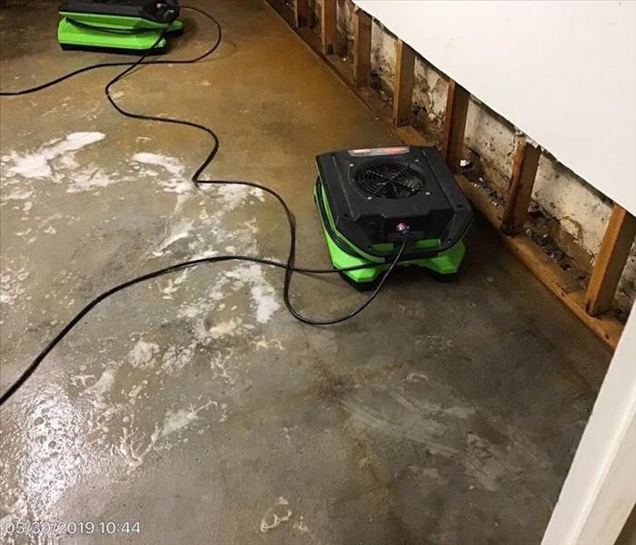 Wet flooring, air dryers, and flood cuts in a basement.